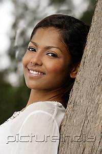 PictureIndia - woman leaning on tree, smiling
