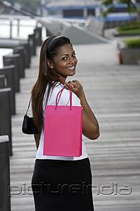 PictureIndia - woman walking outside holding shopping bag and smiling