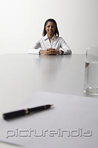 PictureIndia - young woman sitting at end of the table being interviewed