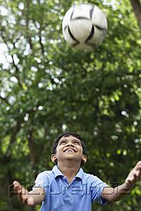 PictureIndia - Young boy looking up and trying to catch the ball