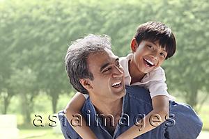 Asia Images Group - Father with son on his back, son smiling at camera
