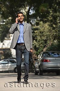 Asia Images Group - man on phone walking with briefcase