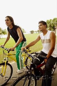 PictureIndia - Two young men sitting on bicycles, looking away