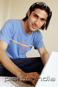 PictureIndia - Man in front of laptop, looking at camera