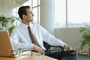 PictureIndia - Male executive turning away from desk, looking at window