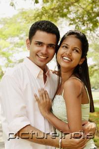PictureIndia - Couple standing cheek to cheek, man looking at camera