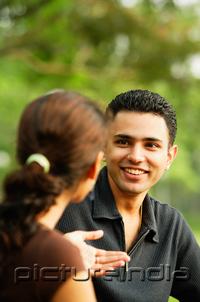 PictureIndia - Man facing woman, smiling, over the shoulder view