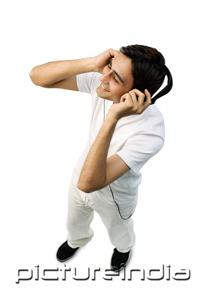 PictureIndia - Young man listening to headphones