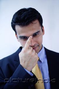 PictureIndia -  Businessman adjusting glasses with finger