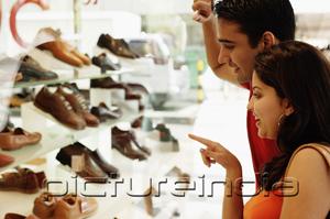 PictureIndia - Couple standing outside shoe shop looking at window display
