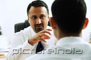 PictureIndia - Two businessmen in office having a discussion, face to face