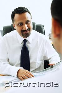 PictureIndia - Businessman facing another person, over the shoulder view