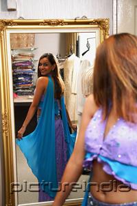 PictureIndia - Woman wearing sari, looking at herself in mirror