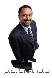 PictureIndia - Businessman holding briefcase, smiling, high angle view
