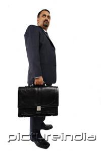 PictureIndia - Businessman standing and holding briefcase