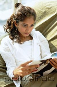 PictureIndia - Woman sitting, reading magazine