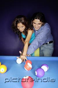 PictureIndia - Couple playing pool, man teaching woman how to play