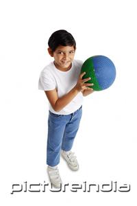 PictureIndia - Boy holding basketball, smiling at camera