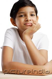 PictureIndia - Boy with hand on chin, looking at camera