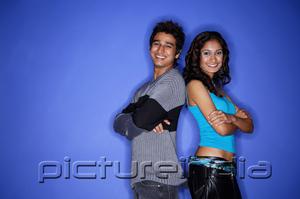 PictureIndia - Couple standing back to back smiling at camera