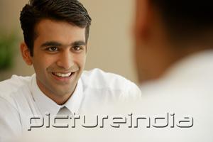 PictureIndia - Businessman smiling at person in front of him