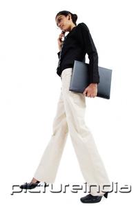 PictureIndia - Business woman with mobile phone, carrying folder, low angle view
