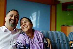 PictureIndia - Mature couple sitting side by side, smiling