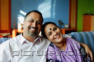 PictureIndia - Mature couple sitting side by side, smiling at camera, portrait