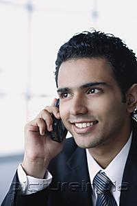 PictureIndia - Young businessman on the phone, smiling, head shot