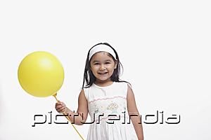 PictureIndia - Young girl in white dress, holding a yellow balloon